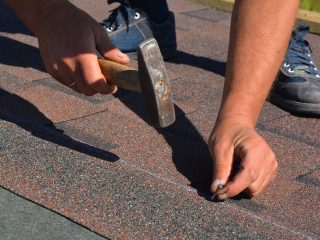 Roofing Contractor Laying Asphalt Shingles. House Roofing