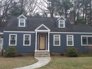 Ranch home with blue cement tile siding as viewed from the curb