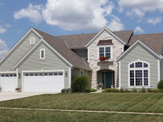 Home with stone entry and green siding